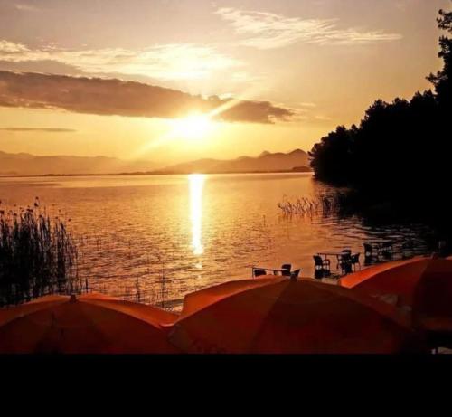 einen Sonnenuntergang über einem Wasserkörper mit Booten in der Unterkunft Sultaniye Camping in Muğla