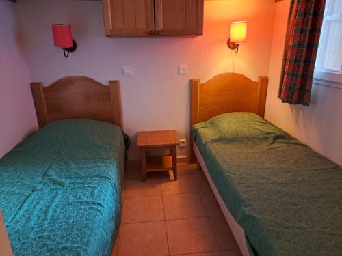 - une chambre avec 2 lits et une table de nuit dans l'établissement Residence du lac Mondesir, à Monflanquin