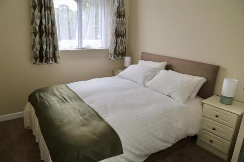 - une chambre avec un grand lit blanc et une fenêtre dans l'établissement Centrally located house on Ring of Kerry, à Killorglin