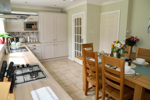 a kitchen with a table and chairs and a stove at Centrally located house on Ring of Kerry in Killorglin