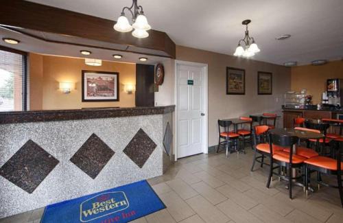 a restaurant with a bar with tables and chairs at Best Western Executive Inn in Grove City