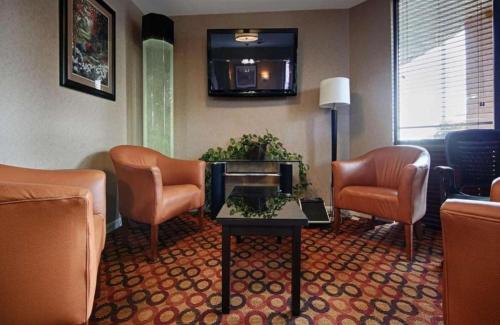 a waiting room with chairs and a table in a hotel room at Best Western Executive Inn in Grove City