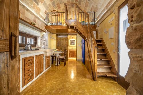 a kitchen with a spiral staircase in a tiny house at Trullo, con giardino privato, a pochi mt dal mare in Torre Suda