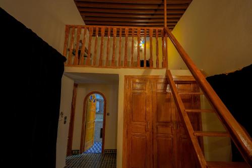a staircase leading up to a room with a wooden door at Riad Sahraui in Fès