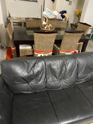 um sofá de couro numa sala de estar com uma mesa e cadeiras em Alvin's House em Tsumeb