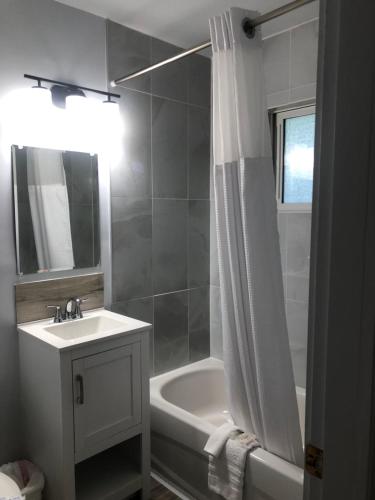 Un baño con lavabo, bañera y ducha. en Bavarian Orchard Motel, en Creston