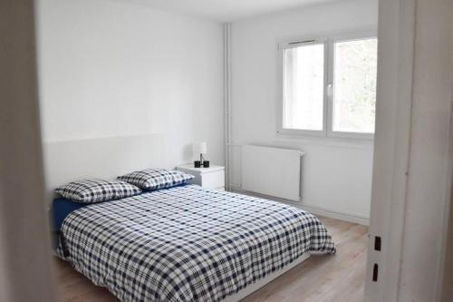 a white bedroom with a bed and a window at Appartement 4 Chambres in Champigny-sur-Marne