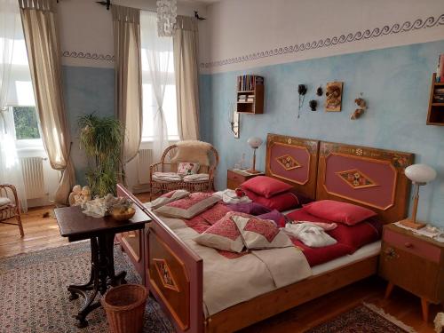 ein Schlafzimmer mit einem Bett mit roten Kissen darauf in der Unterkunft Romantik-Villa LebensART in Reichenfels