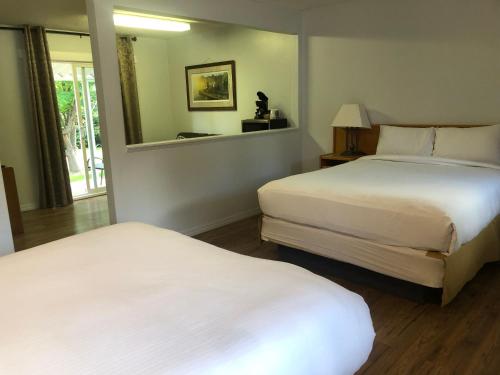 Una habitación de hotel con dos camas y una ventana. en Bavarian Orchard Motel, en Creston