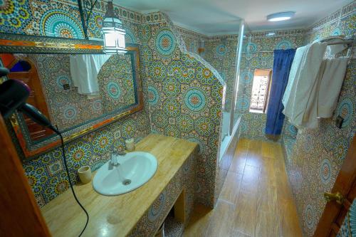 a bathroom with a sink and a mirror at Riad Sahraui in Fès