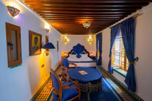 a bedroom with a bed and a table and chairs at Riad Sahraui in Fès