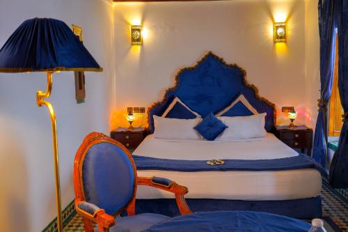 非斯的住宿－Riad Sahraui，一间卧室配有一张床、一把椅子和一盏灯