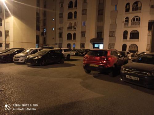 un estacionamiento con autos estacionados frente a un edificio en Ain Naadja Gue De Constantine 