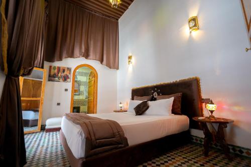 a bedroom with a bed and a chair in a room at Riad Sahraui in Fès