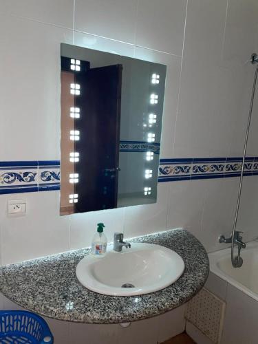 eine Badezimmertheke mit einem Waschbecken und einem Spiegel in der Unterkunft BOUZNIKA BAY COUNTRY CLUB in Bouznika