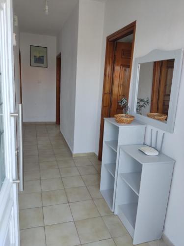a hallway with white shelves and a mirror at Eva's Home in Skala Kallirakhis