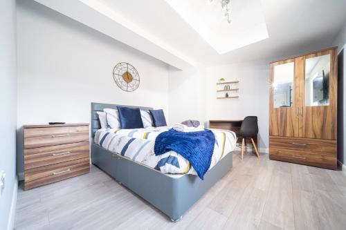 a bedroom with a bed with a wooden dresser and a drawer at Modern Studios with Ensuite, Separate Kitchen, and Prime Location in St Helen Apt 2 in Saint Helens
