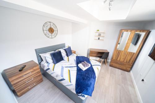 Schlafzimmer mit einem Bett, einer Kommode und einem Spiegel in der Unterkunft Modern Studios with Ensuite, Separate Kitchen, and Prime Location in St Helen Apt 2 in Saint Helens