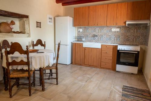 cocina con mesa y horno de fogón blanco en Villa ONAR, en Kalochorafitis