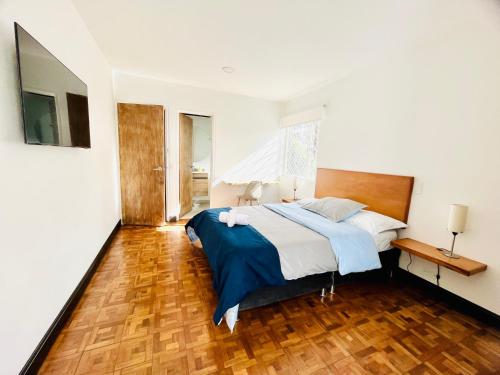 a bedroom with a bed and a wooden floor at Casa ALOHA 152 in Bogotá