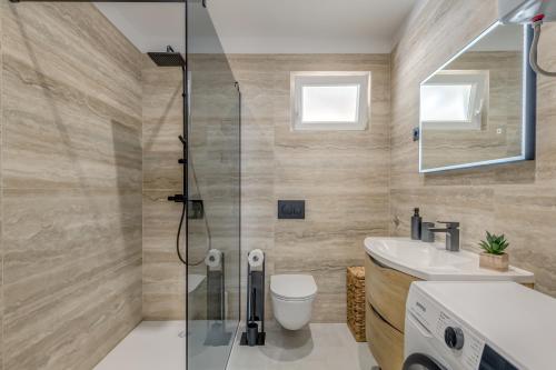 een badkamer met een douche, een toilet en een wastafel bij Luxury apartment on the beach in Trogir