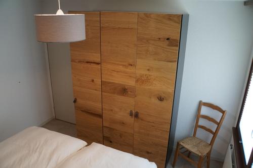 ein Schlafzimmer mit einem großen Holzschrank neben einem Bett in der Unterkunft Apartment EigerView in Grindelwald