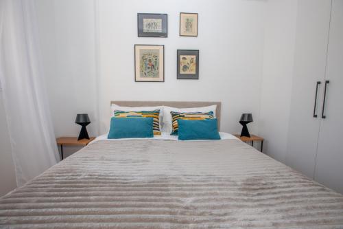 een slaapkamer met een groot bed met 2 blauwe kussens bij Somptueux deux pièces vue mer + parking in Beausoleil