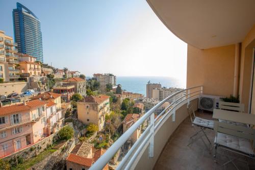 a balcony with a view of the city and the ocean at Somptueux deux pièces vue mer + parking in Beausoleil