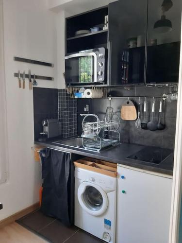 une cuisine avec une machine à laver et un lave-linge dans l'établissement Charmant petit studio tout équipé, à Pantin