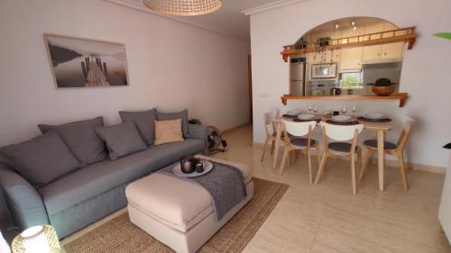 a living room with a gray couch and a table at Heydays Apartment in La Mata