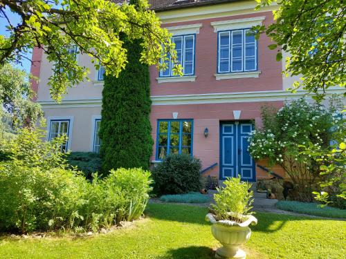 a pink house with a vase in the yard at Romantik-Villa LebensART in Reichenfels