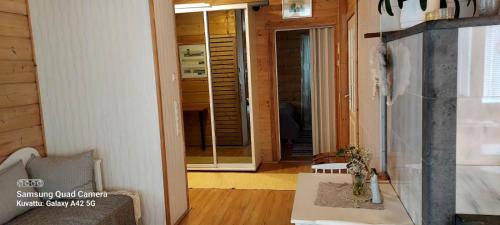 a living room with a door leading into a room with a table at Lintukoto in Ylikiiminki