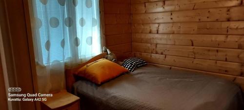 Bett in einem Zimmer mit Fenster in der Unterkunft Lintukoto in Ylikiiminki