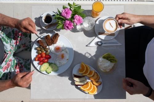 a group of people standing around a table with breakfast foods at Prasonisi Light House Boutique Hotel in Prasonisi