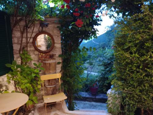 a stone archway with a chair and flowers at Studio Penelope in Kerasochórion