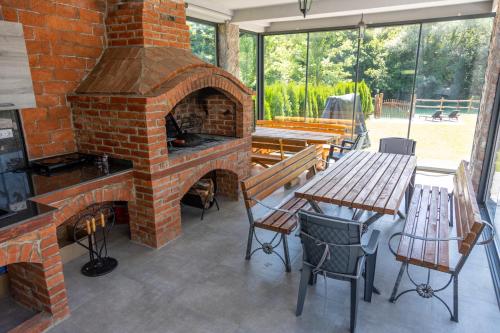 an outdoor brick oven with a table and a bench at Villa UNA LUX in Bihać