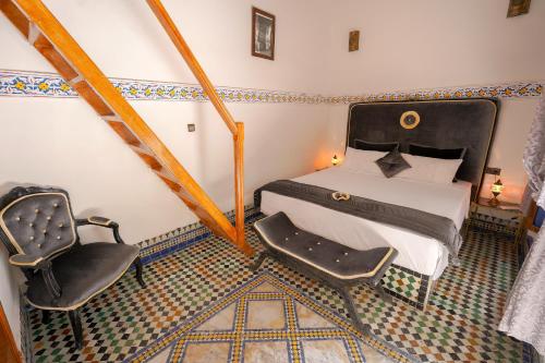 a bedroom with a bed and a chair at Riad Sahraui in Fès