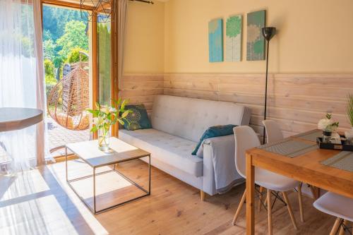 a living room with a couch and a table at Willa Vistula DOMKI na WYŁĄCZNOŚĆ in Wisła