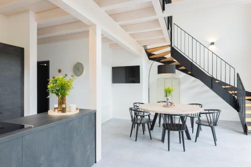 uma sala de jantar com uma mesa e cadeiras e uma escadaria em Ferienhaus MOSELLODGE em Enkirch