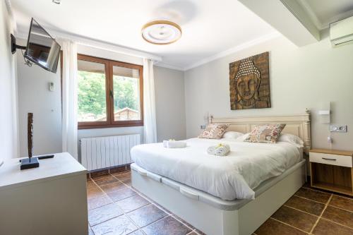 a bedroom with a bed and a flat screen tv at SARREN VILLA POOL by Urdaibai Rentals in Bermeo