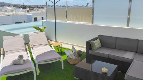 a patio with chairs and a couch on a roof at Apartamentos Mares de Lava - Playa Blanca in Playa Blanca