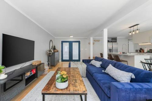 a living room with a blue couch and a table at Bodur's Nest Whispering Garden in Tacoma