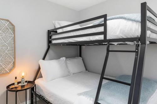 a bedroom with two bunk beds and a table with a lamp at Bodur's Nest Whispering Garden in Tacoma