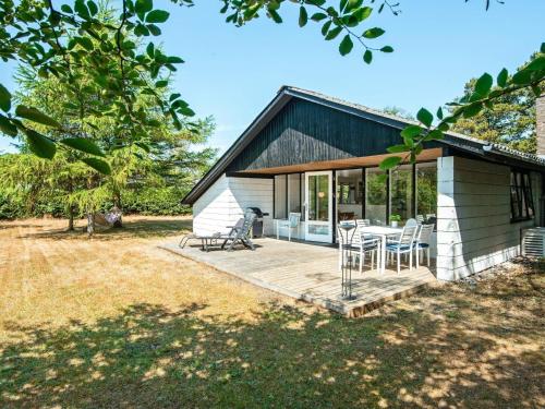 a house with a deck with a table and chairs at 6 person holiday home in Ulfborg-By Traum in Ulfborg