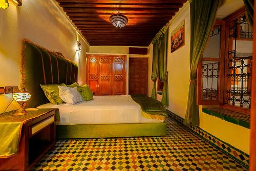 a bedroom with a bed and a table in it at Riad Sahraui in Fès