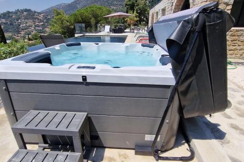 a jacuzzi tub on a patio with a bench at Splendide villa vue mer 180° à 500 m de la plage in Le Lavandou