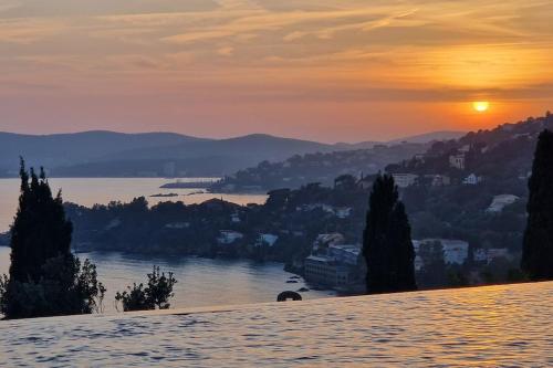 a view of a river at sunset with a city at Splendide villa vue mer 180° à 500 m de la plage in Le Lavandou
