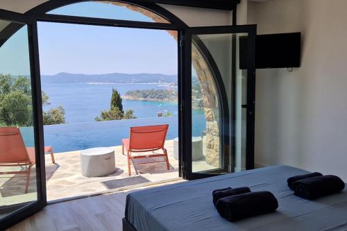 a bedroom with a bed and a view of the water at Splendide villa vue mer 180° à 500 m de la plage in Le Lavandou