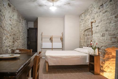 ein Schlafzimmer mit einem Bett und einer Steinmauer in der Unterkunft Monolocale centro storico in Gubbio