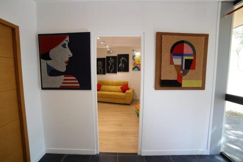 a hallway with two pieces of art on the walls at POP appART Appartement Artiste configuré en Galerie dArt à 200 m du centre ville avec Parking privé et securisé gratuit dans copropriété in Avignon
